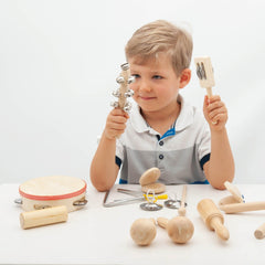 Child playing with wooden kitchen utensils on a white background