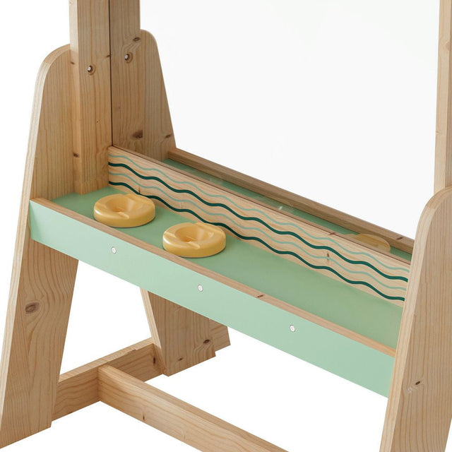 Wooden toy slide with green platform and yellow donut-shaped objects on a white background