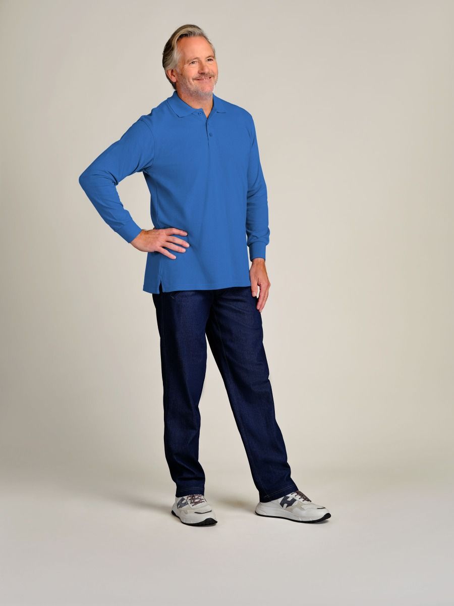 A man modeling a blue long-sleeve quarter-zip pullover and dark navy pants against a plain light beige studio background.