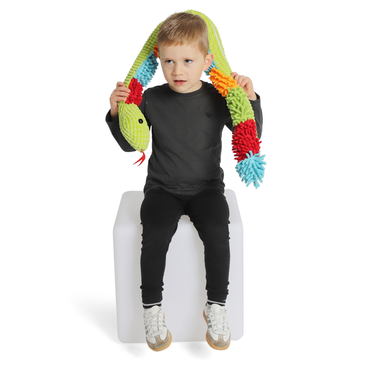Child holding a colorful snake-shaped toy on a white background