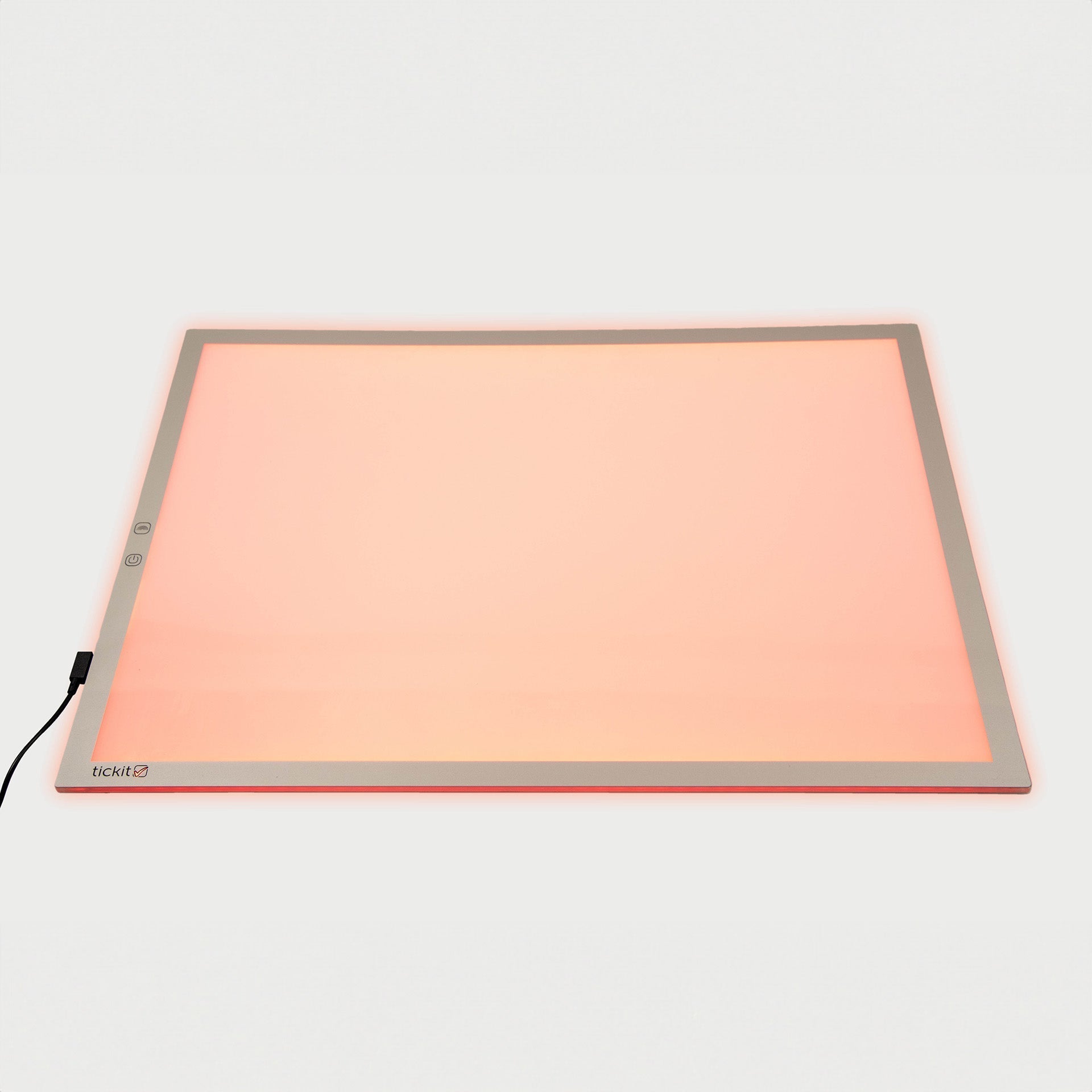 Rectangular light pad with a peach-colored glow on a white background