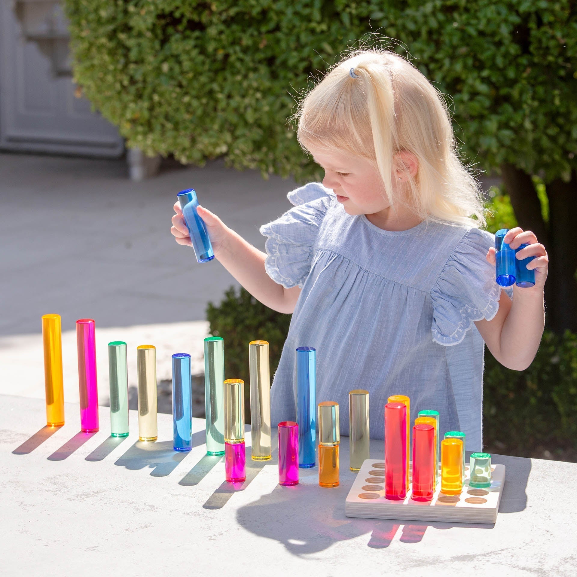 Child playing with colorful test tubes outdoors