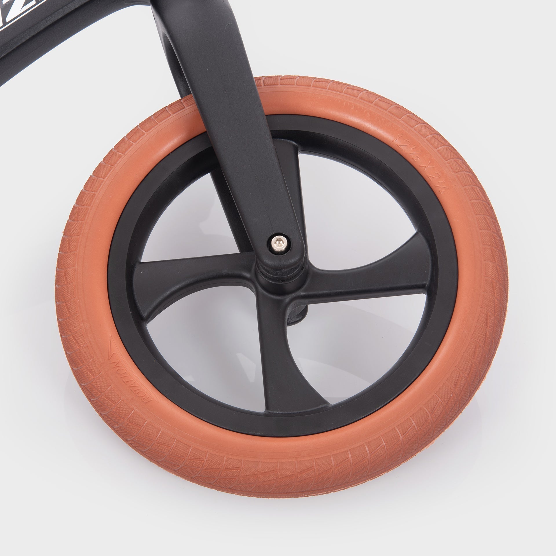 Close-up of a wheel with orange tire and black rim on a white background