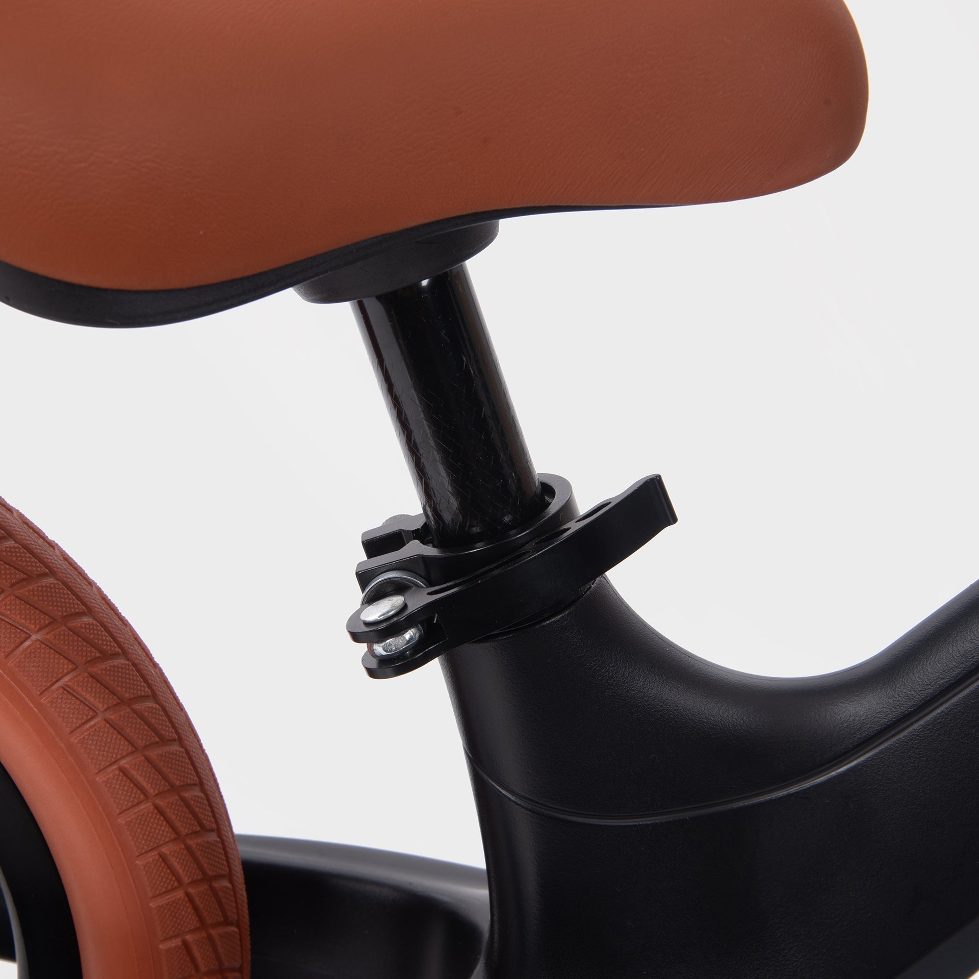 Close-up of a tricycle seat and wheel on a white background