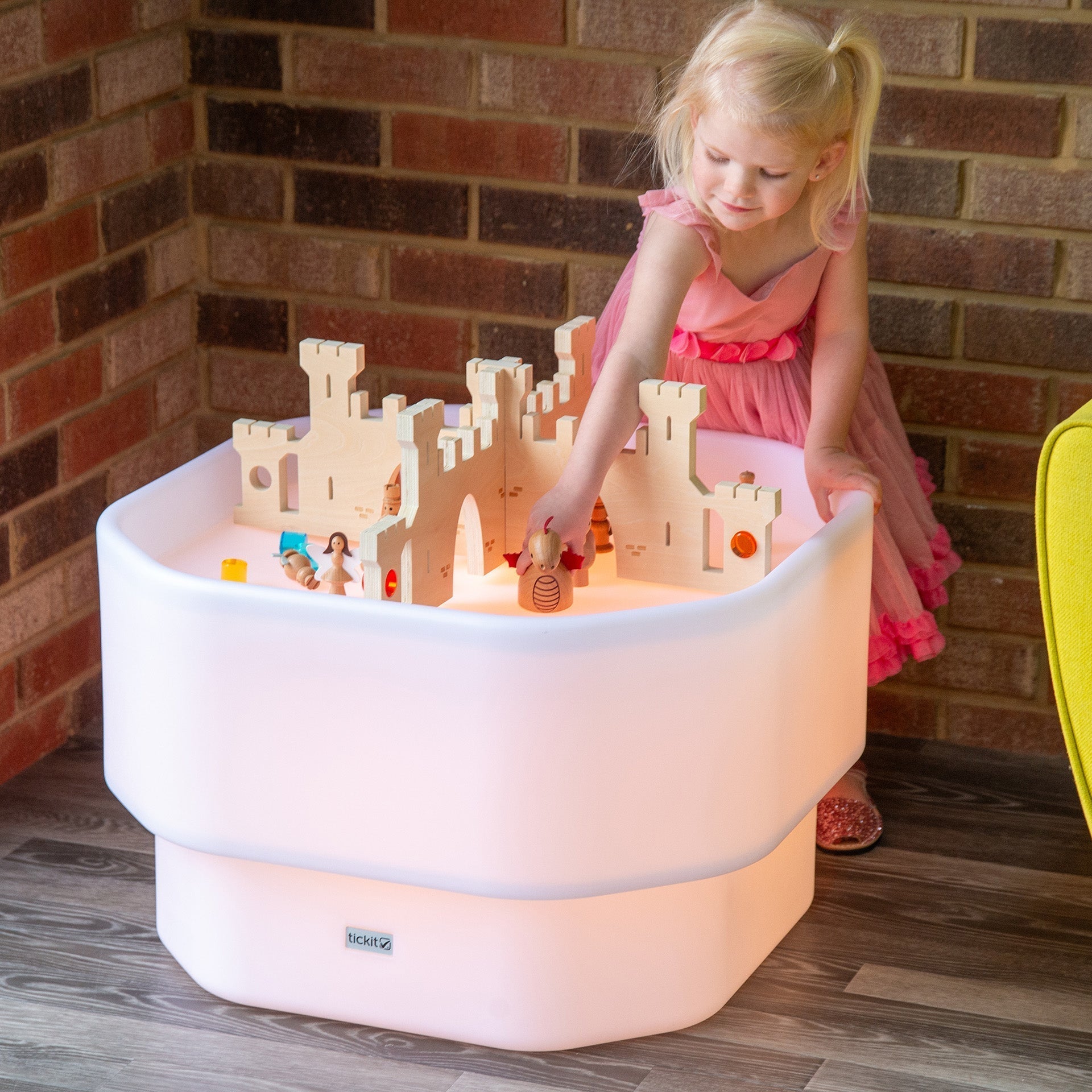 Child playing with a light-up play table featuring a castle design.