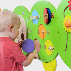 Child interacting with a colorful educational wall panel.