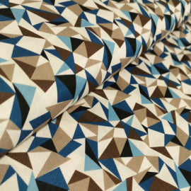A close-up of a draped fabric with a geometric triangle pattern in blue, brown, beige, and white.
