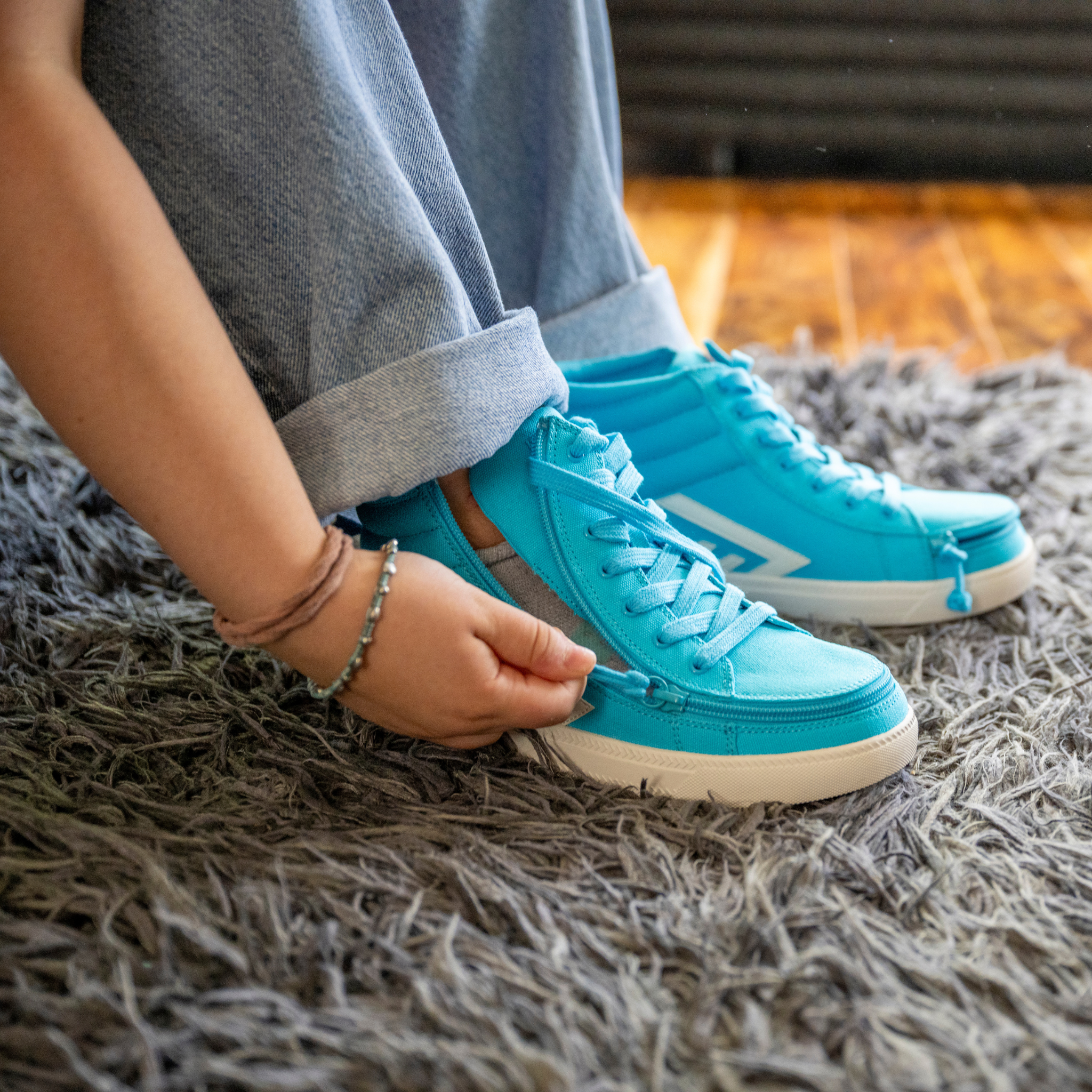 Person wearing bright blue sneakers on a textured surface