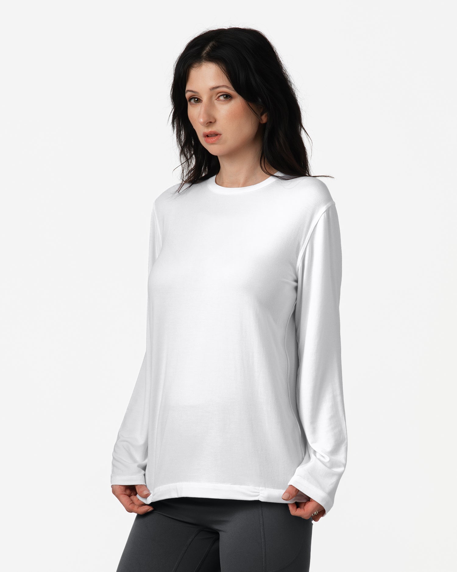 Woman wearing a white long-sleeve shirt against a white background