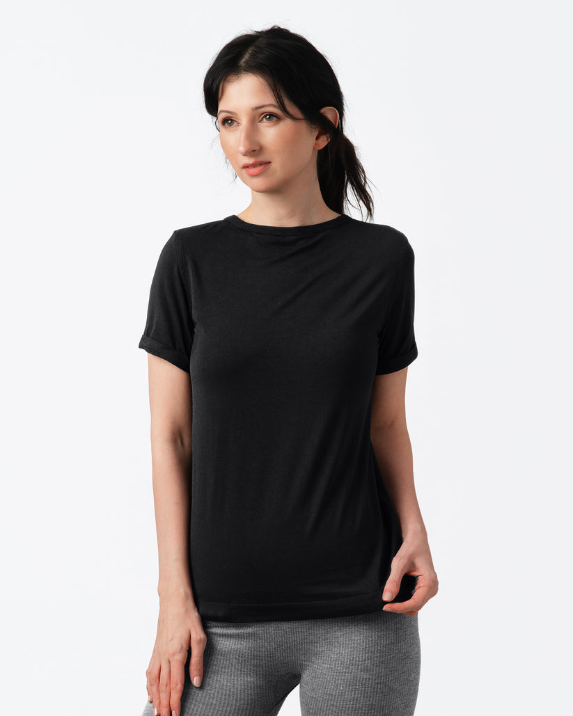 Woman wearing a black t-shirt and gray leggings on a white background