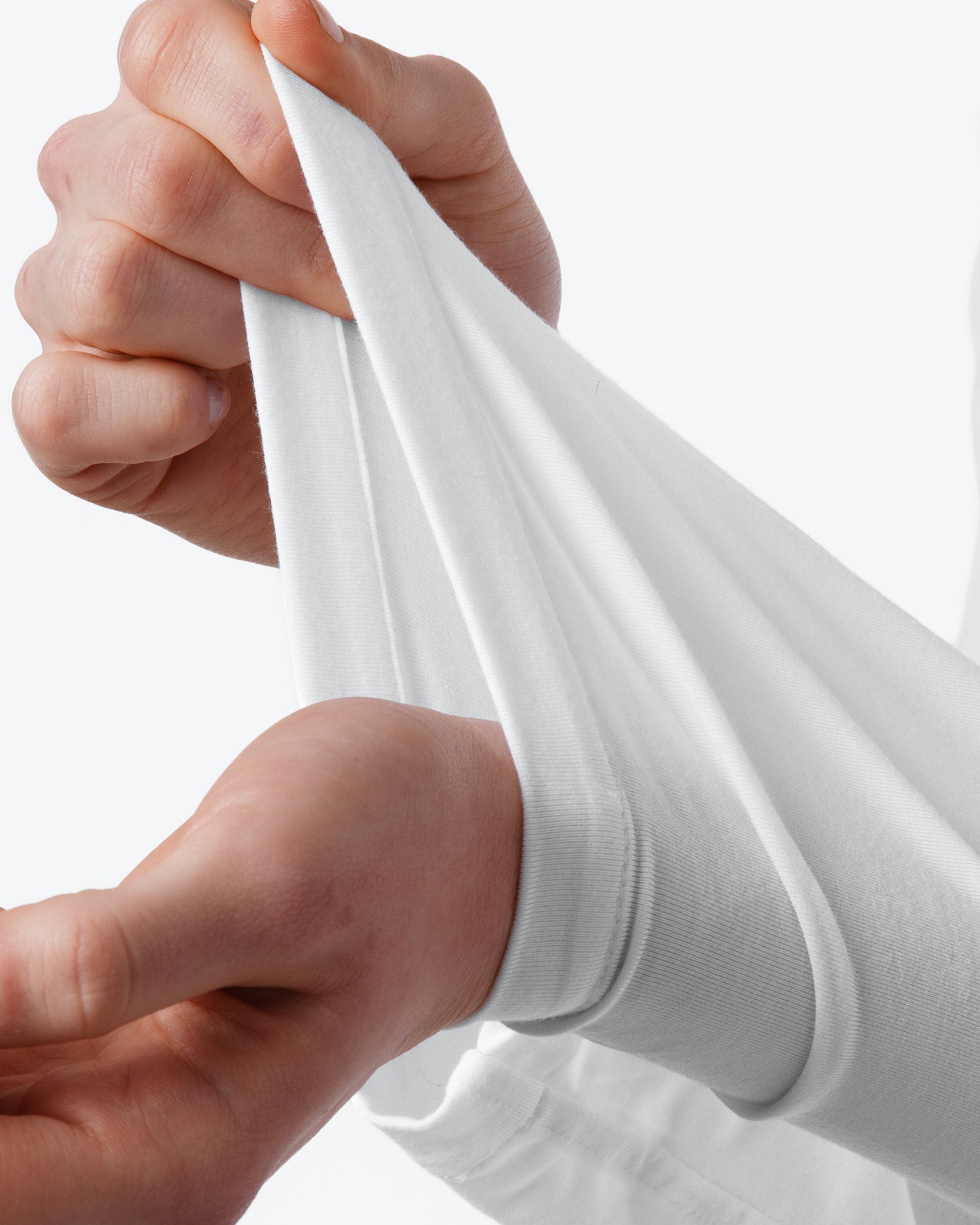 Close-up of hands stretching a white sock against a white background