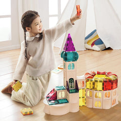 Child playing with colorful transparent building blocks on a wooden floor.