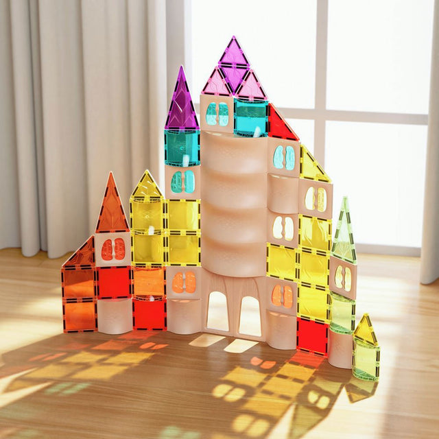 Colorful magnetic building block castle on a wooden floor with a bright background