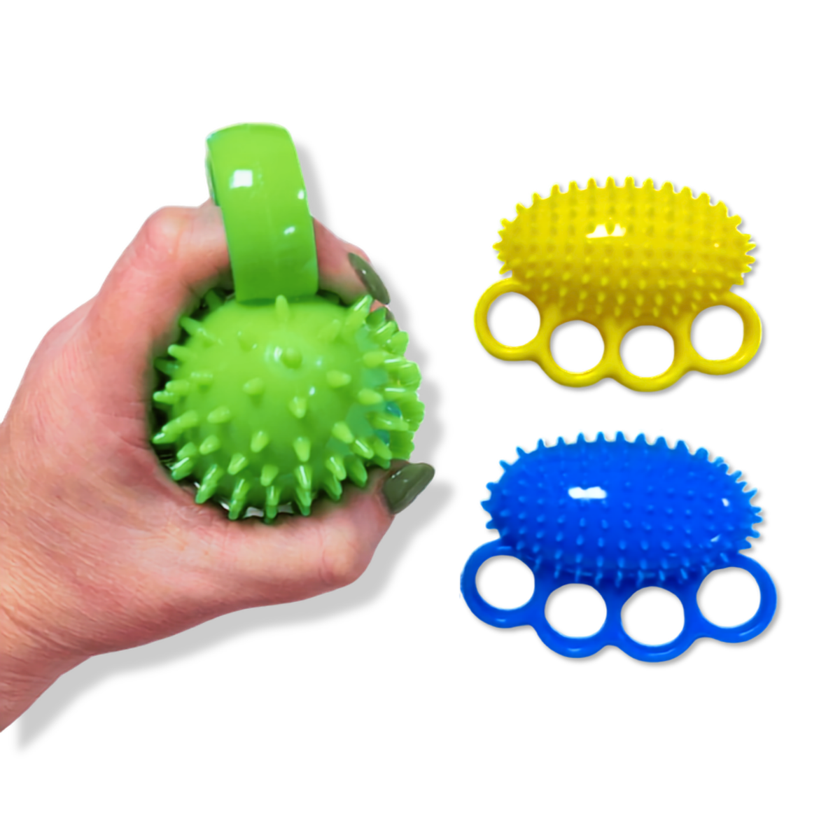 A hand holds a green spiky fist ball with a green ring handle, while two additional spiky fist balls in yellow and blue are displayed on a white background.