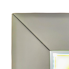 Close-up of the top-left corner of a square framed wall mirror with a textured light gray frame and a reflective silver border.