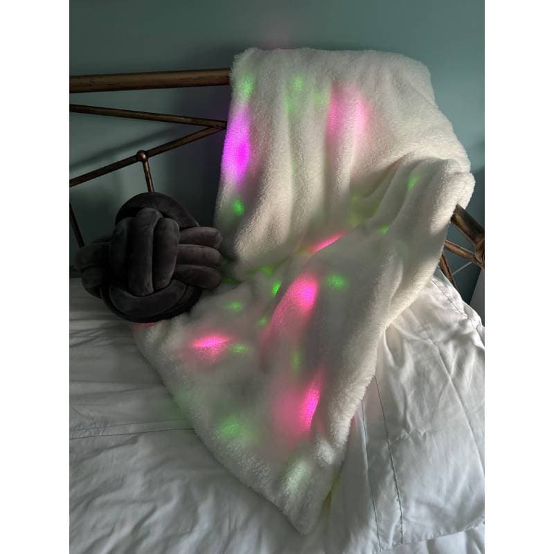 Light-up blanket with colorful lights on a bed